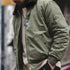 Person wearing a green jacket with a blurred background